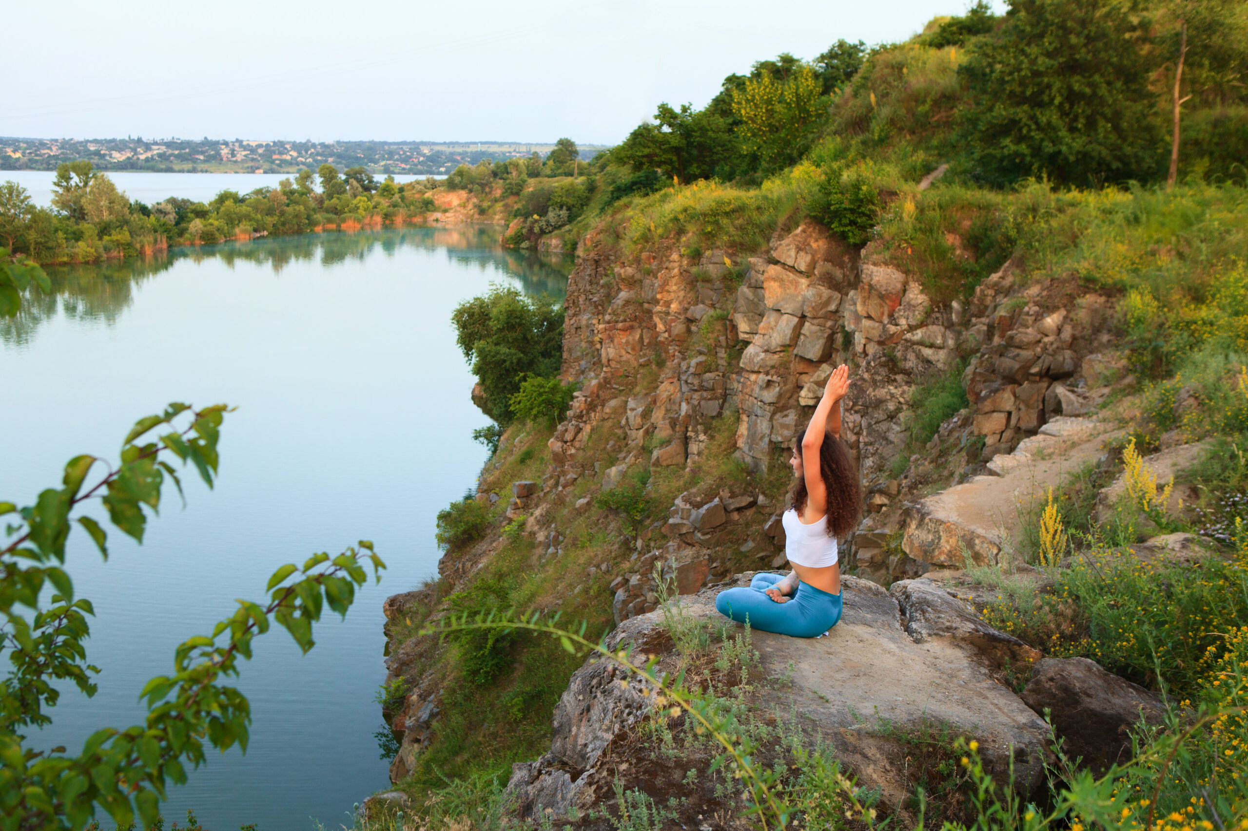 Young woman is practicing yoga at river
